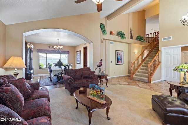 living room with ceiling fan with notable chandelier, light tile patterned flooring, and lofted ceiling with beams