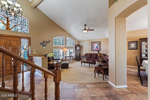 living room with carpet flooring, ceiling fan with notable chandelier, and high vaulted ceiling