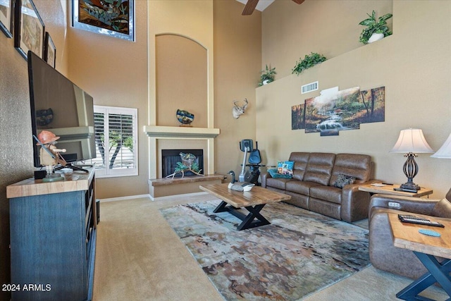 living room featuring light carpet, ceiling fan, and a high ceiling