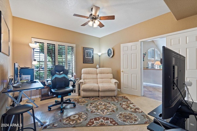 carpeted office featuring a textured ceiling and ceiling fan