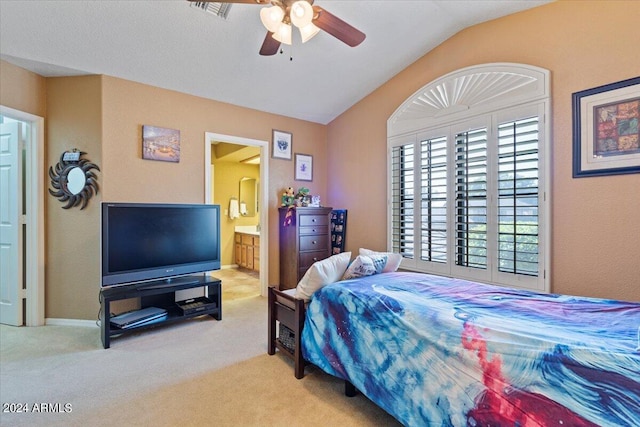 carpeted bedroom featuring ceiling fan, lofted ceiling, and connected bathroom