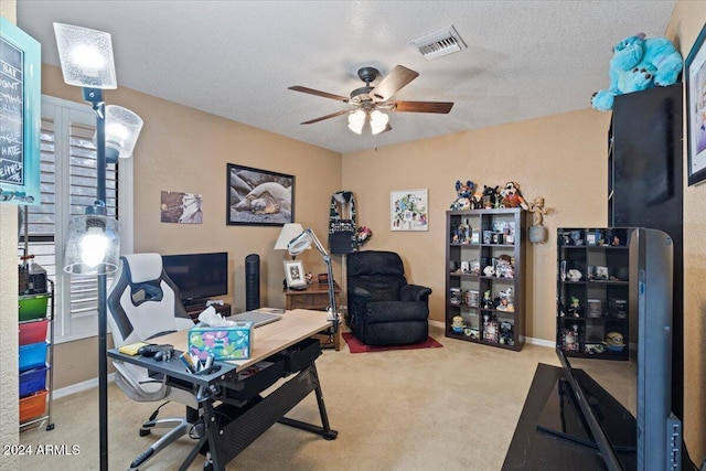 carpeted office space with ceiling fan and a textured ceiling