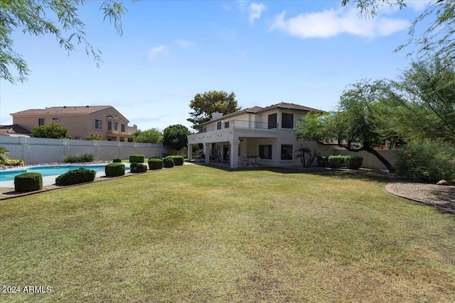 view of yard featuring a balcony and a fenced in pool