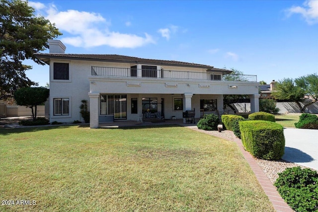 view of front facade featuring a balcony and a front yard