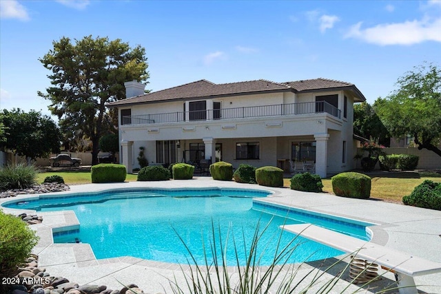 view of pool with a diving board and a patio