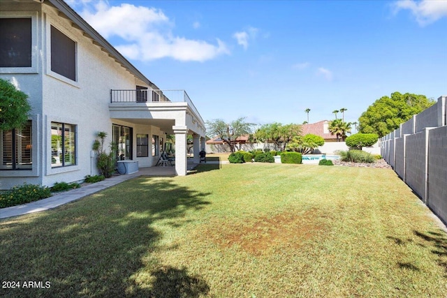 view of yard with a patio and a balcony