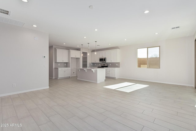 unfurnished living room featuring sink and light wood-type flooring