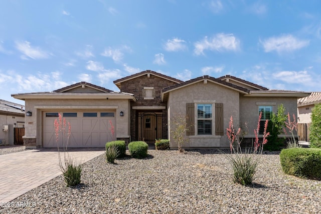 ranch-style home with a tiled roof, decorative driveway, a garage, and stucco siding