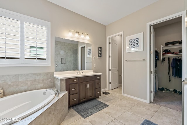full bath with a garden tub, tile patterned flooring, vanity, a spacious closet, and a tile shower