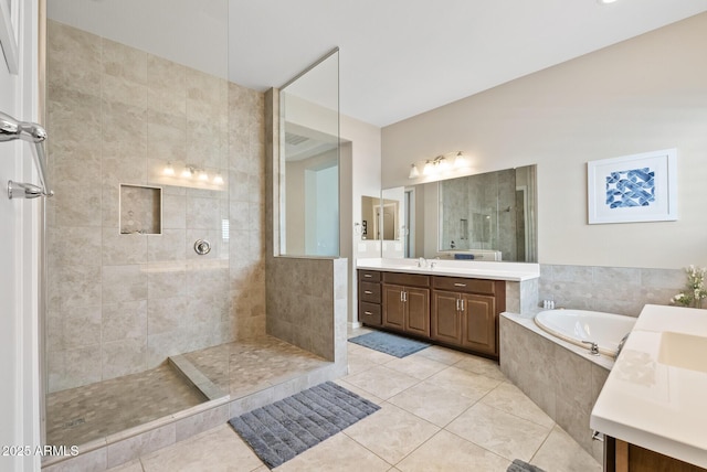 bathroom with tile patterned flooring, a walk in shower, a garden tub, and vanity