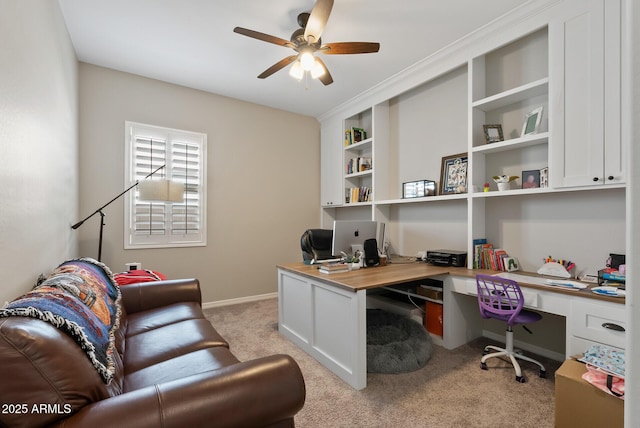 office area with ceiling fan, light carpet, and built in desk