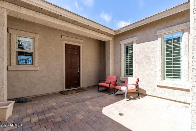 doorway to property with a patio and stucco siding