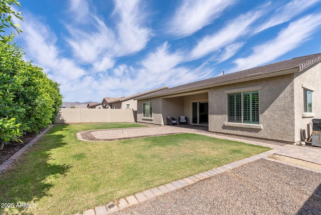 back of house featuring fence, a patio, stucco siding, and a yard