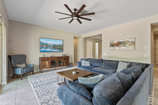 living area with baseboards, a ceiling fan, and light tile patterned floors