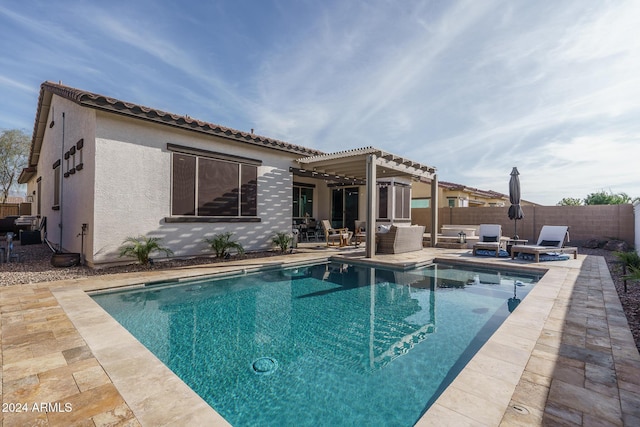 rear view of property featuring a fenced in pool and a patio area