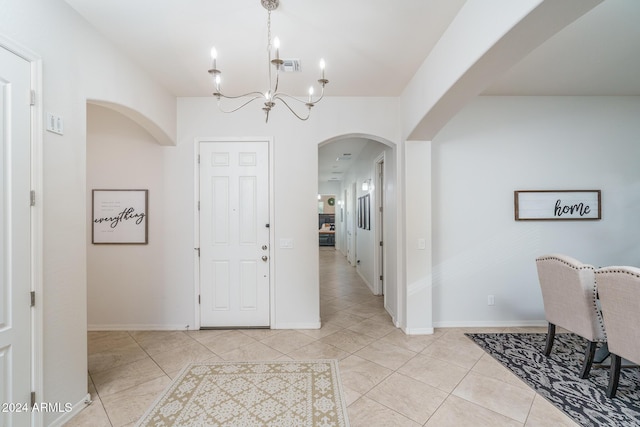 foyer entrance featuring an inviting chandelier and light tile patterned flooring