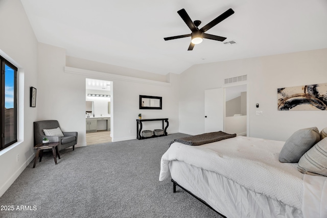 carpeted bedroom with ceiling fan, lofted ceiling, and ensuite bathroom