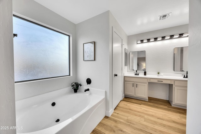 bathroom featuring vanity and a bath