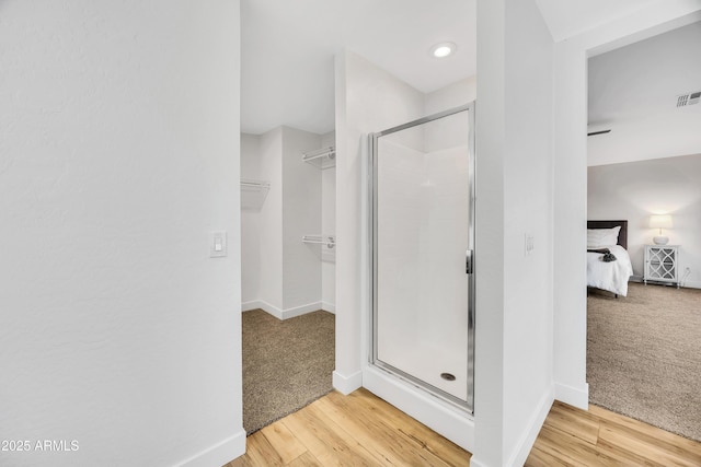 bathroom featuring walk in shower and hardwood / wood-style floors