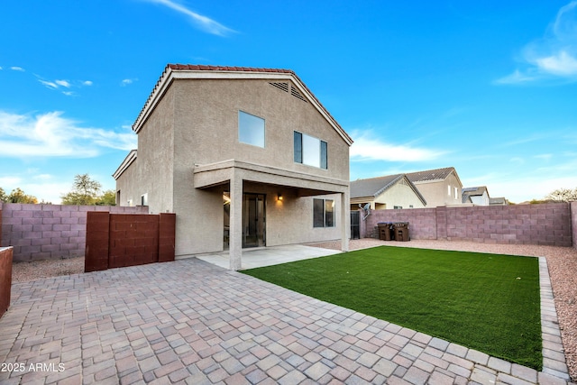 rear view of property with a yard and a patio