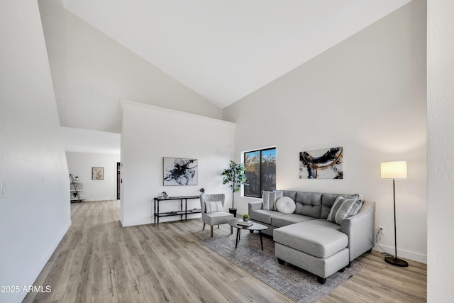 living room with high vaulted ceiling and light wood-type flooring