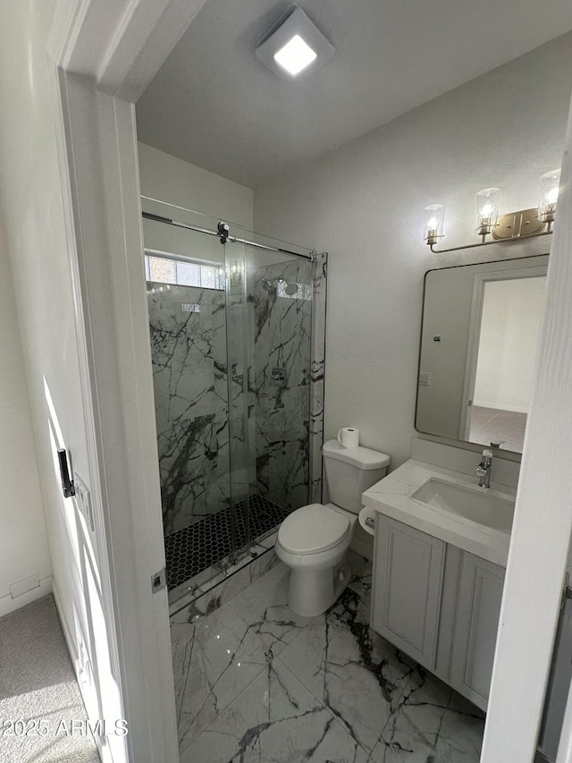 bathroom featuring marble finish floor, toilet, vanity, and a marble finish shower