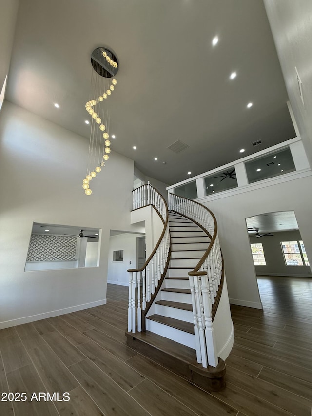 staircase featuring baseboards, wood finished floors, visible vents, and recessed lighting