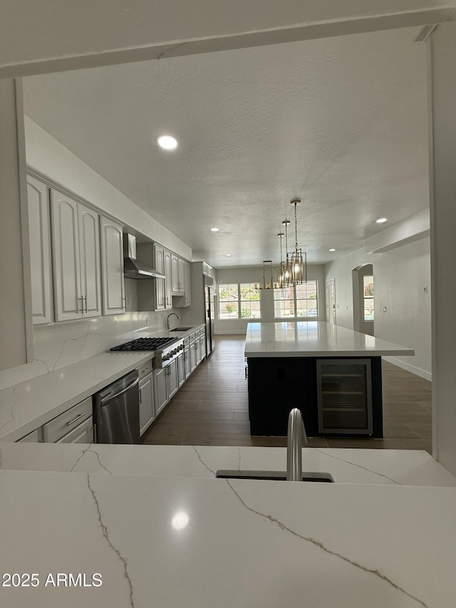 kitchen featuring recessed lighting, wood finished floors, stainless steel appliances, and wine cooler