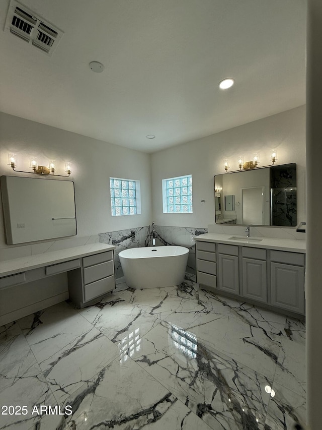 full bathroom featuring recessed lighting, marble finish floor, visible vents, vanity, and a soaking tub