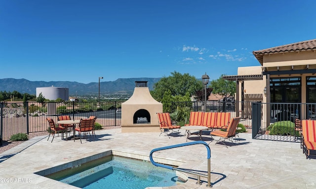 4968 E Meadow Vista Dr, Cornville, AZ 86325 - view of swimming pool with a community hot tub, an outdoor fireplace, fence, a mountain view, and a patio area