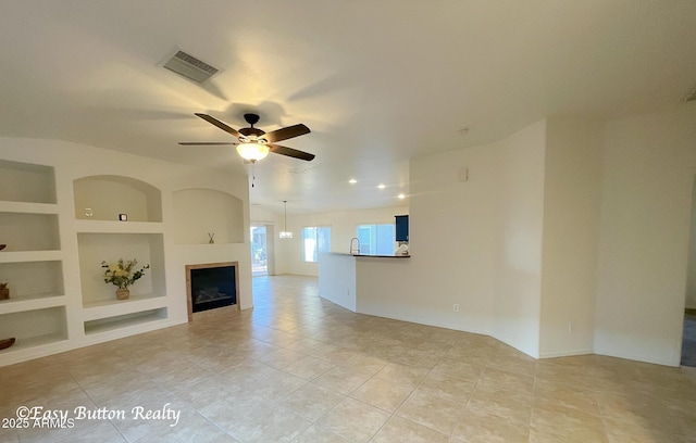 4968 E Meadow Vista Dr, Cornville, AZ 86325 - unfurnished living room with built in features, a ceiling fan, visible vents, light tile patterned floors, and a fireplace
