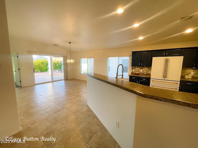 4968 E Meadow Vista Dr, Cornville, AZ 86325 - kitchen featuring dark cabinetry, light tile patterned floors, freestanding refrigerator, backsplash, and a chandelier