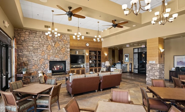 4968 E Meadow Vista Dr, Cornville, AZ 86325 - living area featuring visible vents, a high ceiling, a stone fireplace, and ceiling fan with notable chandelier