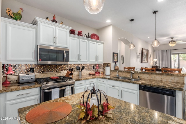 kitchen with hanging light fixtures, white cabinetry, ceiling fan, and stainless steel appliances