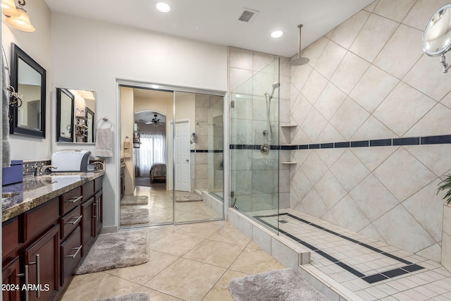 bathroom with tile patterned flooring, ceiling fan, a shower with door, and vanity