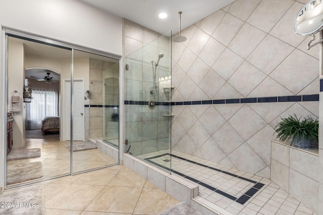 bathroom featuring tile patterned flooring, ceiling fan, and a shower with door