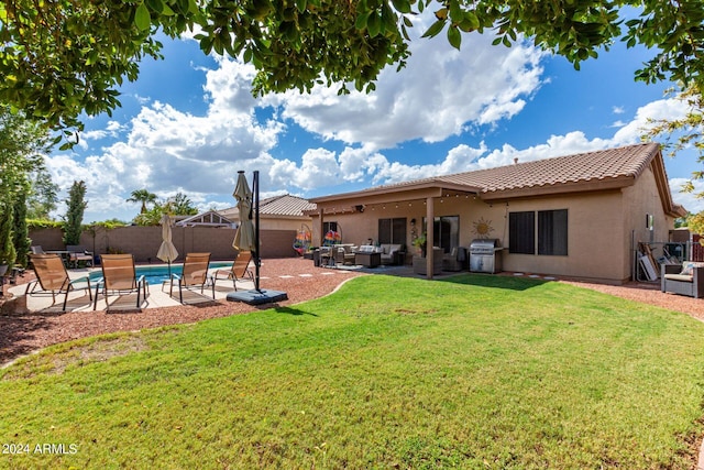 rear view of property featuring a lawn, a patio, and an outdoor living space