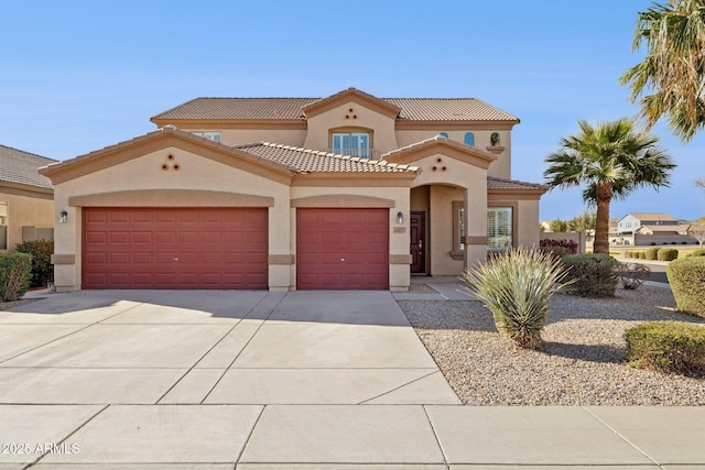 mediterranean / spanish-style house with stucco siding, driveway, an attached garage, and a tiled roof