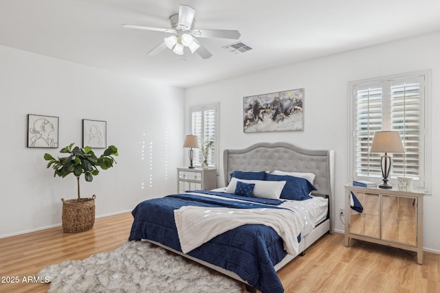 bedroom featuring ceiling fan, wood finished floors, visible vents, and baseboards