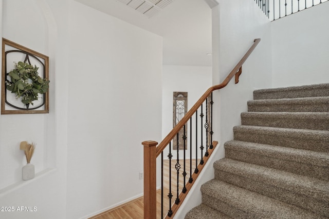 staircase with wood finished floors and baseboards