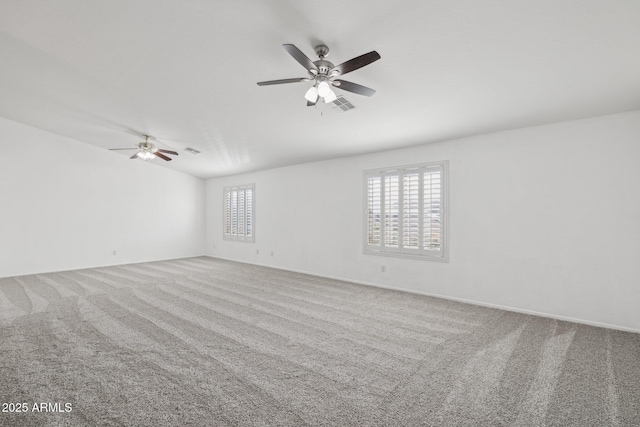 carpeted spare room with visible vents and ceiling fan