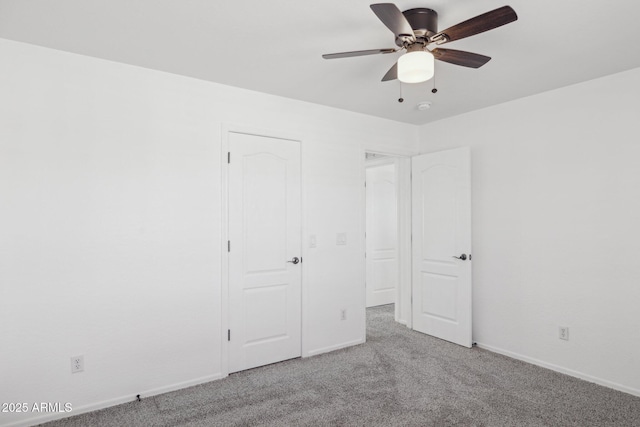 unfurnished bedroom featuring baseboards, carpet, and a ceiling fan