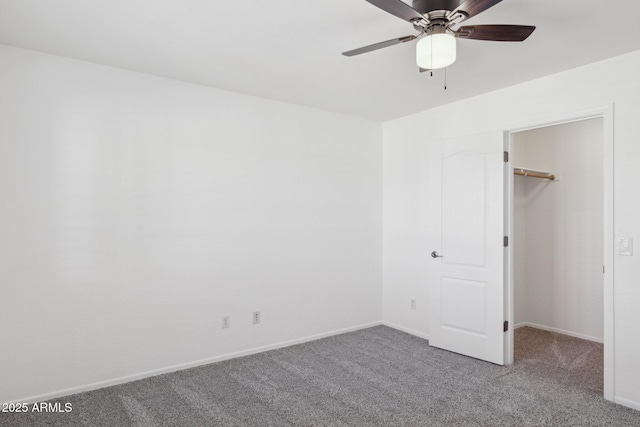 unfurnished bedroom featuring a closet, baseboards, carpet, and a spacious closet