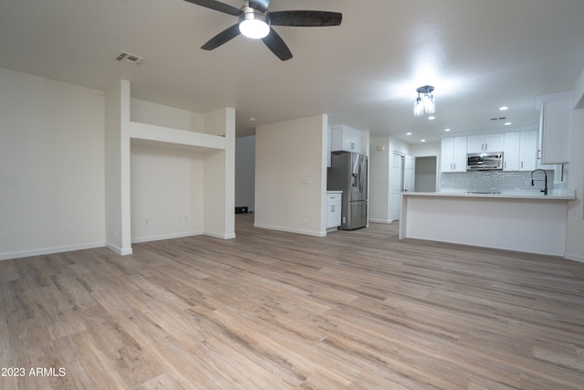 unfurnished living room with ceiling fan and light hardwood / wood-style floors