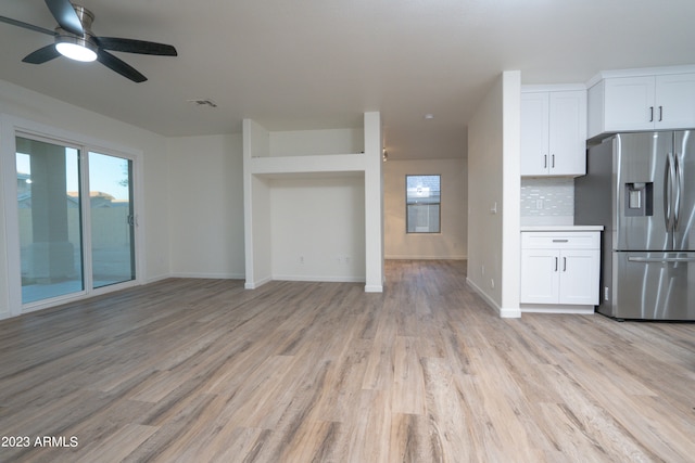 kitchen featuring ceiling fan, stainless steel fridge, tasteful backsplash, white cabinetry, and light hardwood / wood-style floors