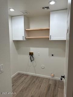 washroom with washer hookup, hookup for a gas dryer, electric dryer hookup, cabinets, and hardwood / wood-style floors