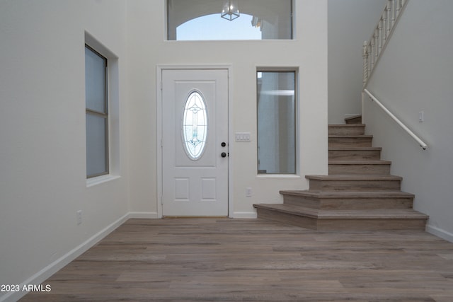 foyer featuring a towering ceiling and light hardwood / wood-style flooring