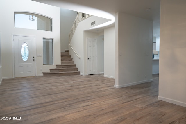 foyer entrance with a towering ceiling and hardwood / wood-style floors