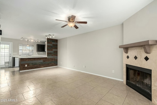 unfurnished living room featuring ceiling fan, a fireplace, and light tile patterned floors