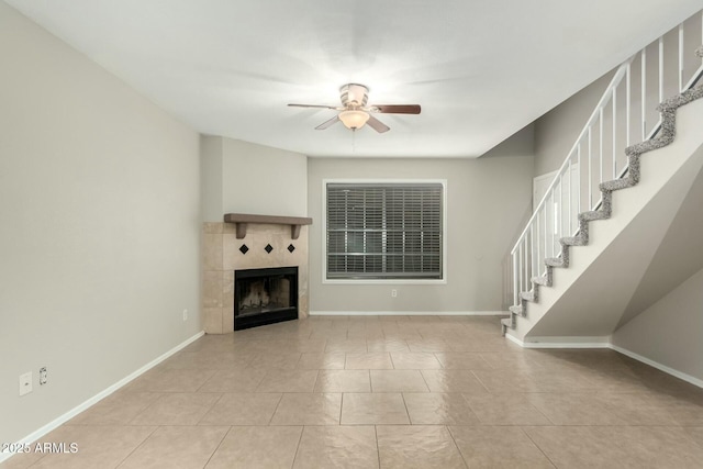 unfurnished living room with a tile fireplace, ceiling fan, and light tile patterned flooring